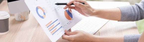 Business team reviewing financial charts and data on computer screen during meeting.
