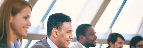 Row of business people listening to presentation at seminar with focus on elegant young man